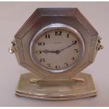 A hallmarked silver mounted eight day desk clock, octagonal engine turned, the shaped rectangular