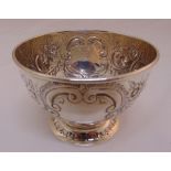 A hallmarked silver sugar bowl chased with flowers and scrolls on raised circular base, marks rubbed