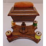 A Regency mahogany sewing set of casket form on quatrefoil base supporting four cotton reels and pin