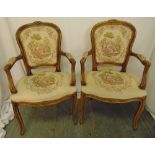 A pair of French mahogany upholstered armchairs with scrolling arms on cabriole legs