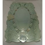 A Venetian glass wall mirror of shaped rectangular form with central oval plate, engraved with