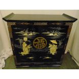 A rectangular oriental style black lacquered cocktail cabinet with hinged top, double doors