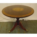 A circular mahogany side table with inlaid satinwood to the centre all on three outswept legs with