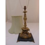 A gilt metal table lamp of scroll chased baluster form on square marble base to include silk
