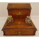 An early 20th century rectangular oak ink stand with hinged compartment, two detachable glass