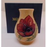 Moorcroft clay coloured vase decorated with a purple and a red flower, marks to the base, in