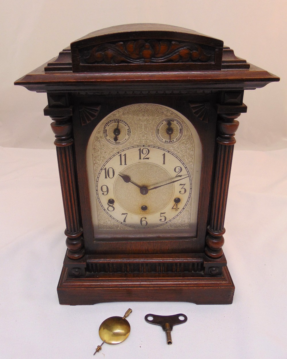 An oak cased bracket clock with silvered dial, Arabic numerals and two subsidiary dials, to