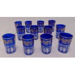 A set of twelve blue and gold Bohemian style glasses of faceted cylindrical form, 10cm (h)