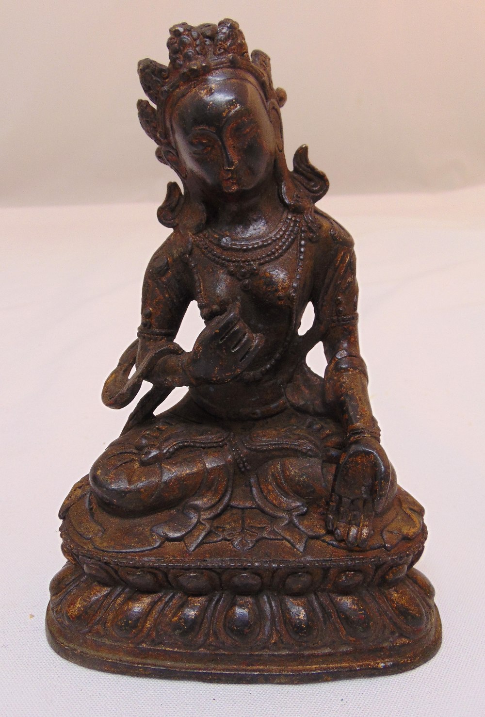 A Chinese gilded bronze figurine of a Buddha on raised oval plinth, 16cm (h)