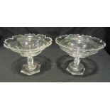A pair of Irish Regency glass comports of circular form with scroll borders, knopped stems on raised