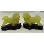 A pair of Oriental carved green hardstone lions to include hardwood stands, 10cm (h)