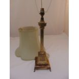 A gilt metal table lamp of Corinthian column form on raised square base with scroll supports to