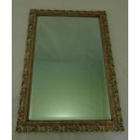 A rectangular scroll pierced and stained wooden mirror with bevelled edge, 73.5 x 51cm