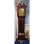 An early 19th century mahogany longcase clock with swan neck pediment carved figural terminals