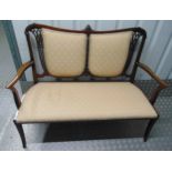 An Edwardian mahogany upholstered settle with scrolling arms and pierced back on four cabriole legs