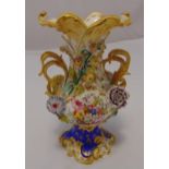 A continental two handled vase in Rococo style profusely decorated with flowers and leaves on shaped