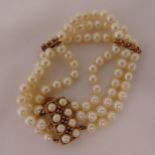 Three strand cultured pearl bracelet with 9ct gold, pearl and ruby clasp