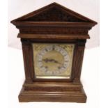 An oak cased mantle clock of architectural form, two train movement, silvered chapter ring with