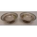 A pair of hallmarked silver bonbon dishes, circular with pierced sides on raised circular bases,