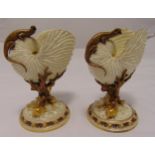 A pair of Royal Worcester Nautilus shell vases with applied lizards and coral supports on raised