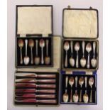 Three cased sets of hallmarked silver coffee spoons and a cased set of tea knives with hallmarked