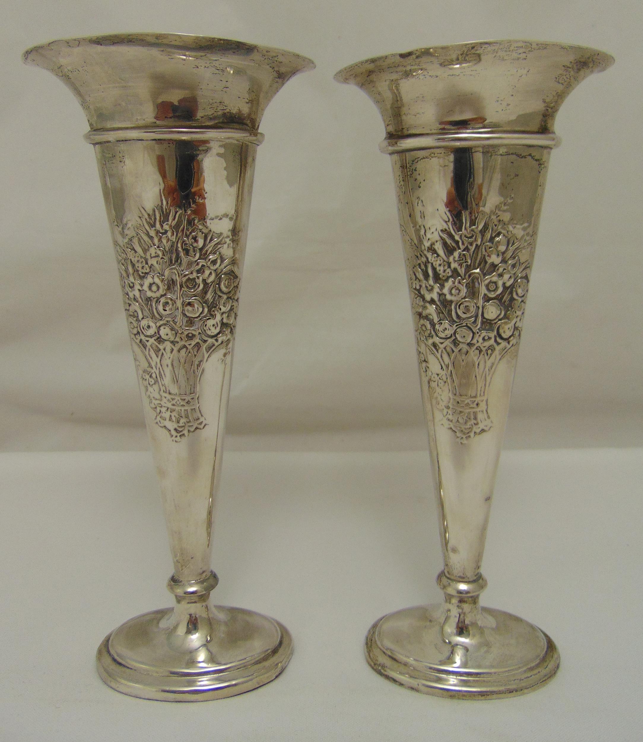 A pair of hallmarked silver vases, tapering compressed oval decorated to the sides with basket of