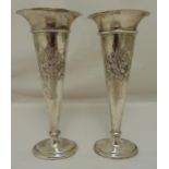 A pair of hallmarked silver vases, tapering compressed oval decorated to the sides with basket of