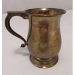 A hallmarked silver baluster form mug with scroll handle on raised circular base, Birmingham 1975,