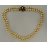 A double strand cultured pearl necklace with 9ct gold, garnets and pearl clasp, 42cm long