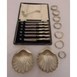 A quantity of silver and white metal to include a pair of shell shaped dishes, napkin rings, a sauce