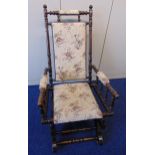 An oak rocking chair with upholstered seat and back and turned sides, arms and back