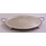 A Victorian oval hallmarked silver tea tray, engraved to the centre with leaves, scrolls and