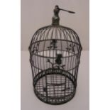 A Victorian style cylindrical metal bird cage with hinged door and turned finial to the top, 43cm (