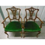 A pair of Edwardian occasional armchairs with scrolling arms and scroll pierced backs on four leaf