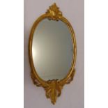 A gilded wooden oval wall mirror, 76 x 38cm