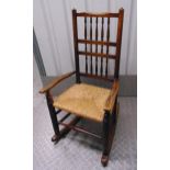 A Victorian oak Cotton Mill spindle rocking chair with rush matting seat