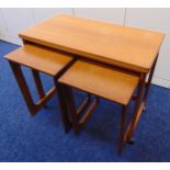 A rectangular teak tea table with revolving folding top and two matching side tables by Macintosh of