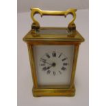A French brass carriage clock of customary form, the white enamel dial with Roman numerals