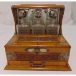 A Victorian tantalus cum cigar box, rectangular, three cut glass bottles with drop stoppers the