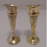 A pair of hallmarked silver vases, tapering cylindrical, floral and leaf chased sides on raised