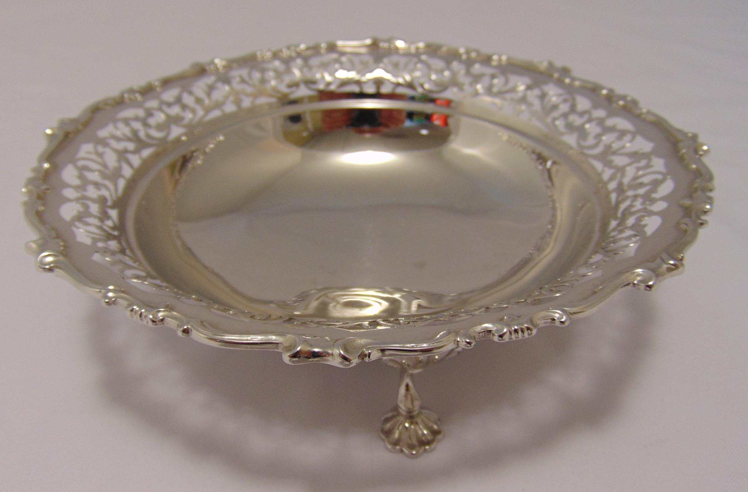 A hallmarked silver cake stand circular scroll pierced sides with scroll border on three scrolling