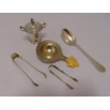 A continental white metal strainer, a white metal miniature cup and cover with scroll handles and