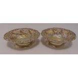 A pair of Victorian hallmarked silver bonbon dishes, oval scroll pierced sides chased with flowers
