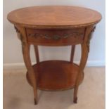 An oval mahogany and Kingswood side table with applied gilded mounts and a single drawer on four