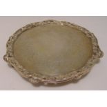 A Victorian hallmarked silver salver, circular with vine and shell pierced border on three vine