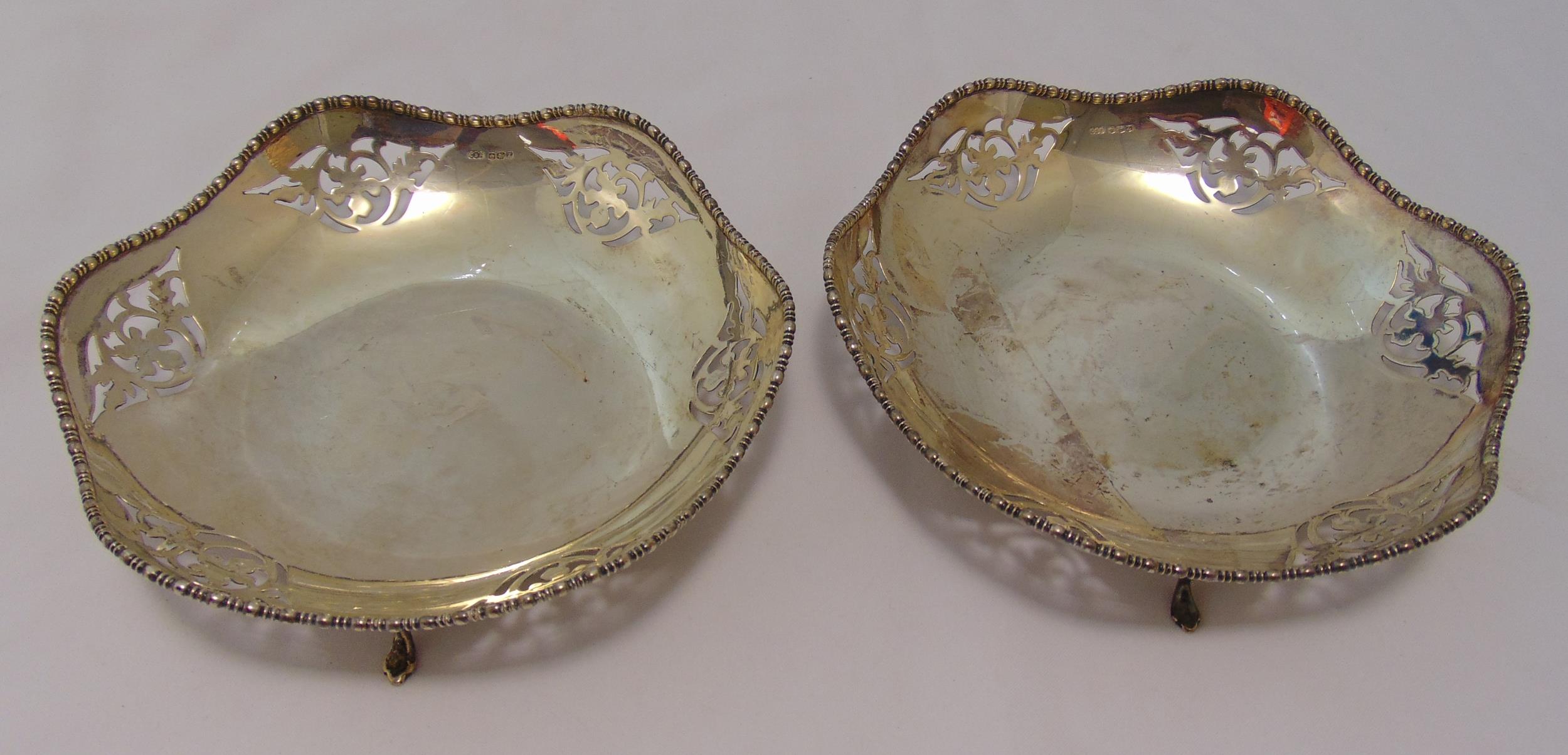 A pair of silver hallmarked cake stands, circular scroll pierced sides with beaded borders on scroll