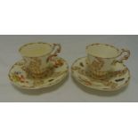 A pair of Copeland cabinet cups and saucers decorated with flowers and leaves