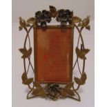 A brass rectangular Art Nouveau style photograph frame with floral and leaf pierced surround, 27 x