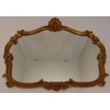 A shaped oval gilded wooden wall mirror carved with scrolls and shells, 70 x 81cm