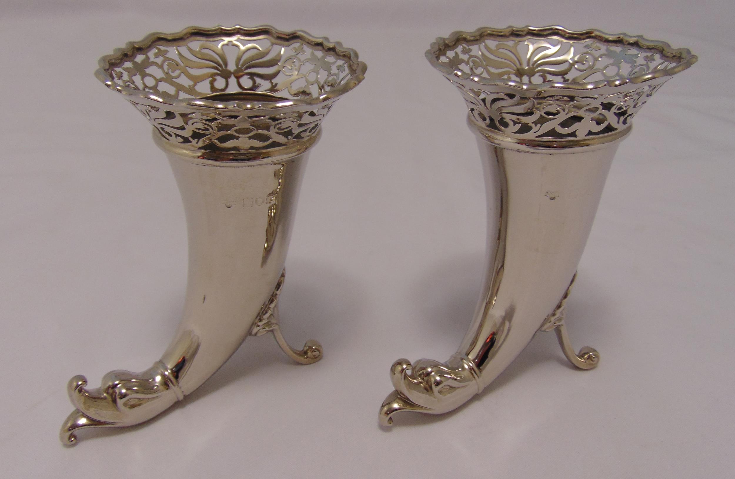 A pair of Goldsmiths and Silversmiths Company silver vases of horn shape with scroll pierced tops